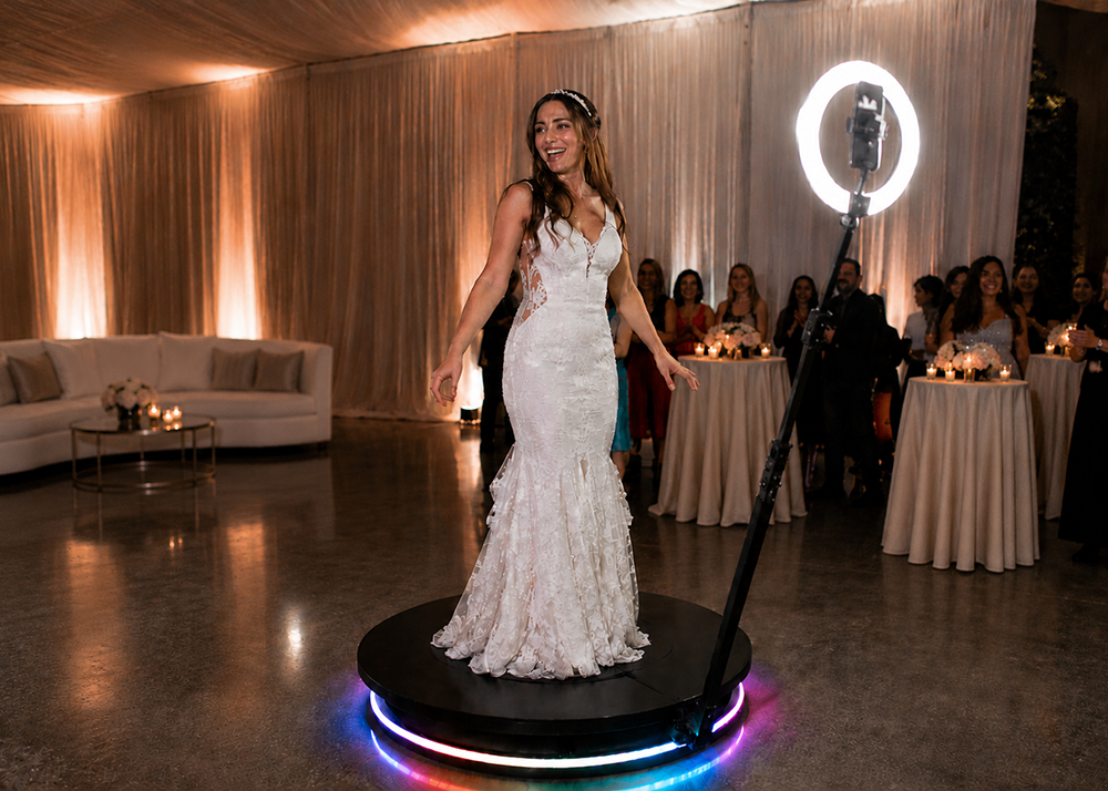 Bride using a 360 degree video booth experience at a luxury wedding reception