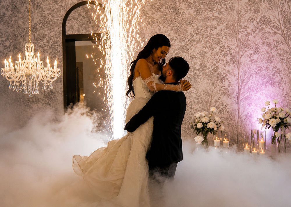 Bride and groom sharing their first dance with cold sparkler and dry ice effects at a luxury wedding