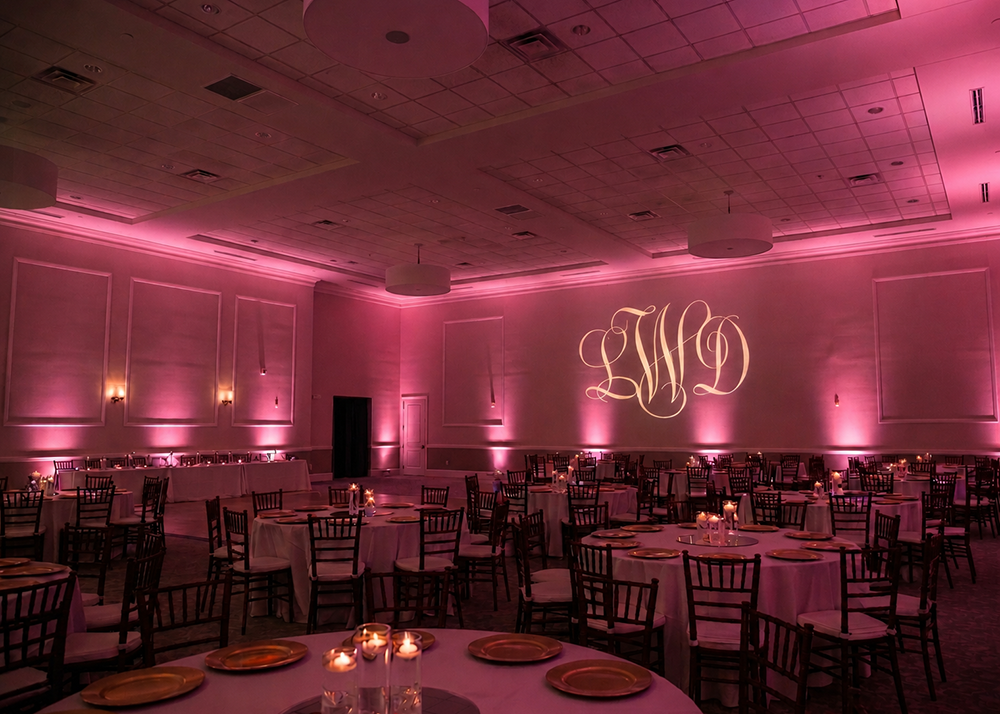 Wedding reception venue featuring a personalised monogram gobo projection and ambient lighting