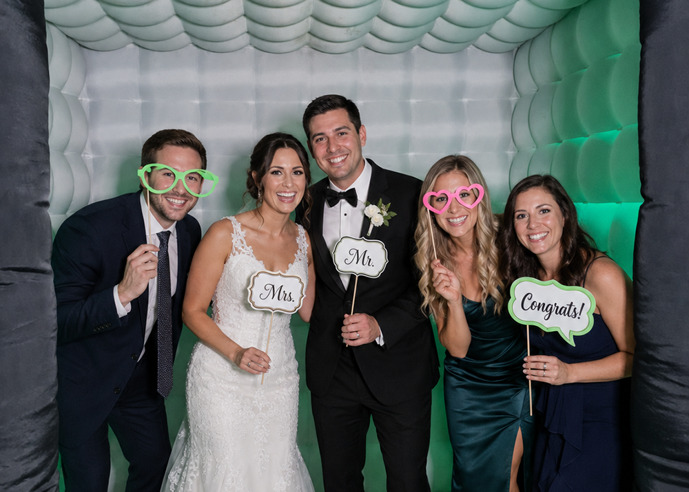 Wedding guests enjoying an inflatable photo booth experience at a luxury wedding reception