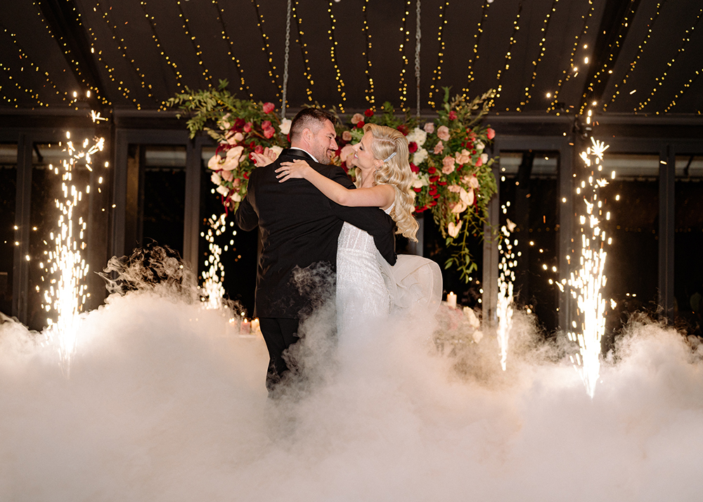 ride and groom sharing their first dance surrounded by a dry ice effect