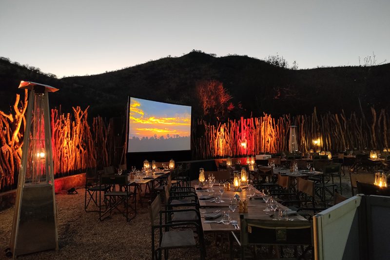 Outdoor event setup with projection screen and ambient lighting by Cream Cheese Premier DJs & Events